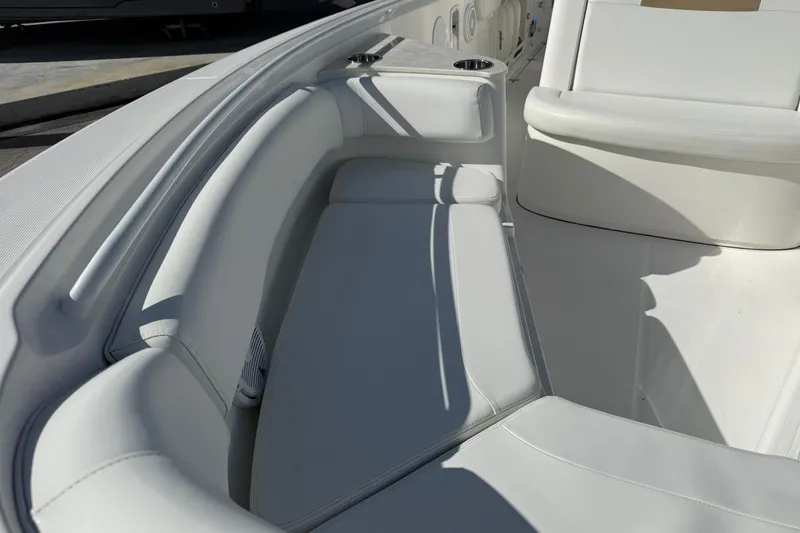 Slide: The Image of Interior seating of 2021 Edgewater 262CC boat, featuring white cushioned seats. - 33