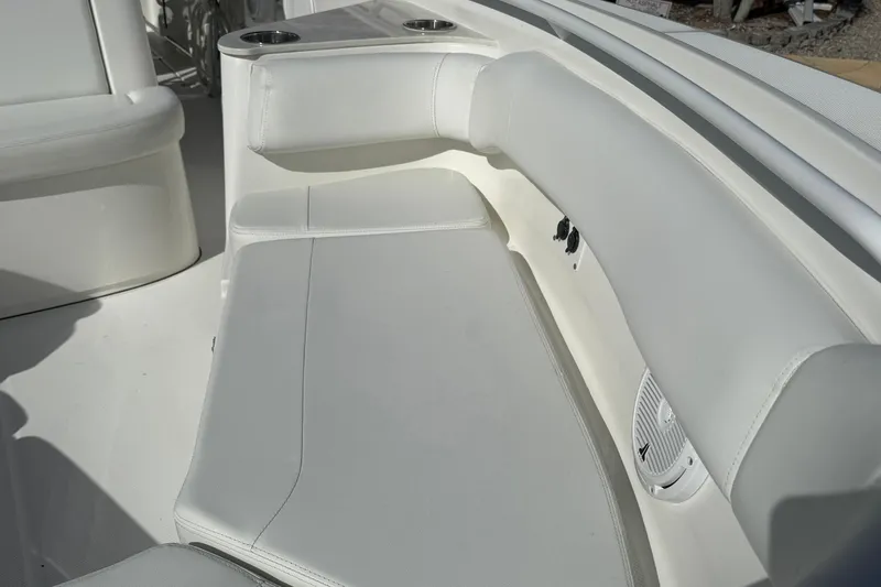 Slide: The Image of 2021 Edgewater 262CC boat interior with white cushioned seating and cup holders. - 34