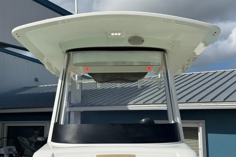 Slide: The Image of 2021 Edgewater 262CC boat with T-top and rod holders, against a cloudy sky. - 36