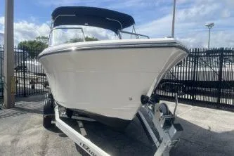 Slide: The Image of 2023 Cobia 220 Dual Console boat on trailer, parked outdoors. - 2