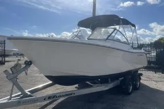 Slide: The Image of 2023 Cobia 220 Dual Console boat on trailer under clear sky. - 3