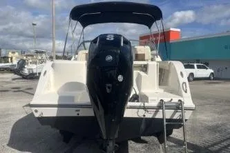 Slide: The Image of 2023 Cobia 220 Dual Console boat with outboard motor, parked outdoors. - 5
