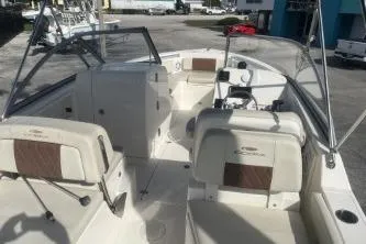 Slide: The Image of 2023 Cobia 220 Dual Console boat interior with seating and steering wheel. - 7