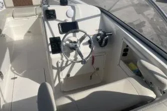 Slide: The Image of 2023 Cobia 220 Dual Console boat interior with steering wheel and controls. - 8