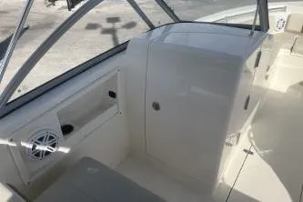 Slide: The Image of 2023 Cobia 220 Dual Console interior with seating and storage compartments. - 9