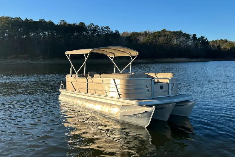 The Image of 2022 Godfrey Sweetwater 2286 C pontoon boat on a serene lake. - 1