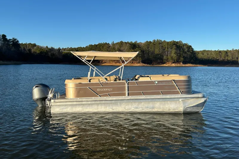 Slide: The Image of 2022 Godfrey Sweetwater 2286 C pontoon boat on a serene lake. - 10