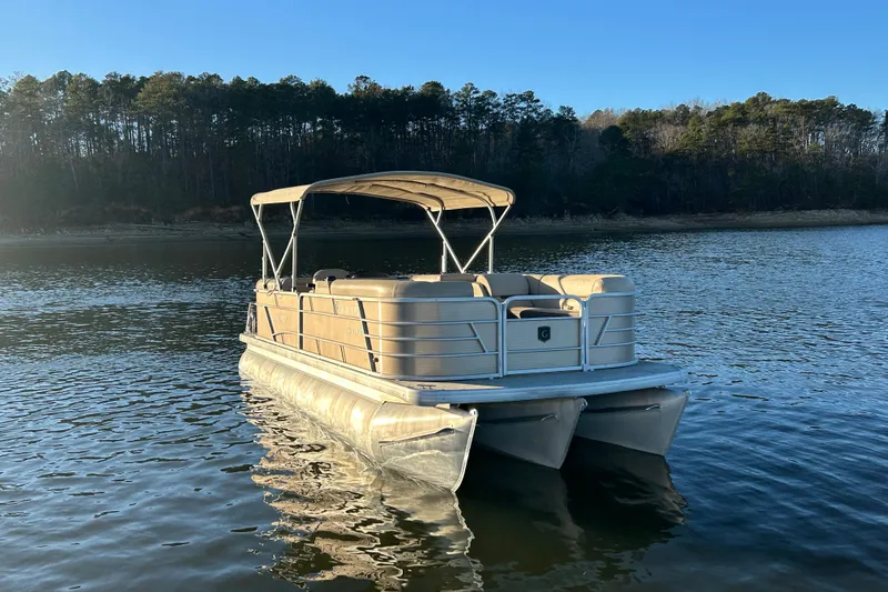 Slide: The Image of 2022 Godfrey Sweetwater 2286 C pontoon boat on a serene lake with forest backdrop. - 11