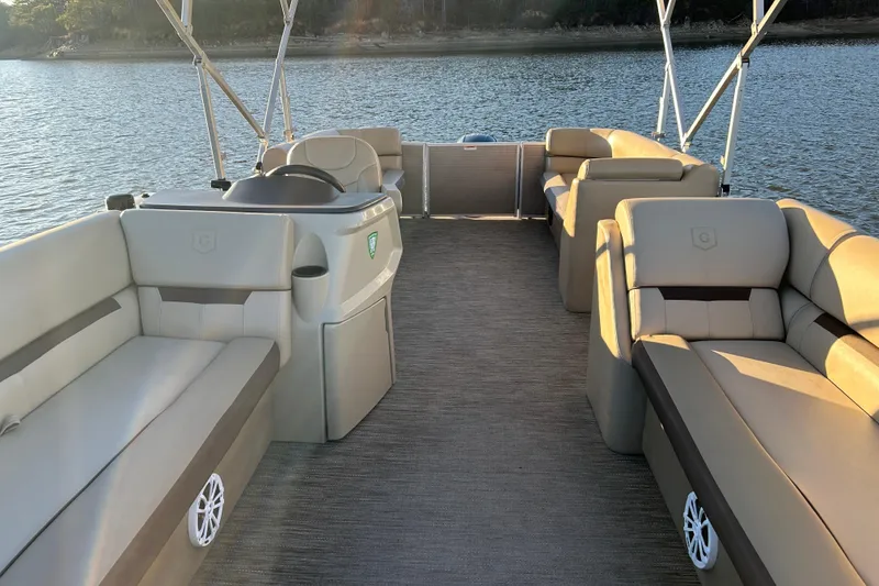 Slide: The Image of 2022 Godfrey Sweetwater 2286 C pontoon boat interior with plush seating on a serene lake. - 13