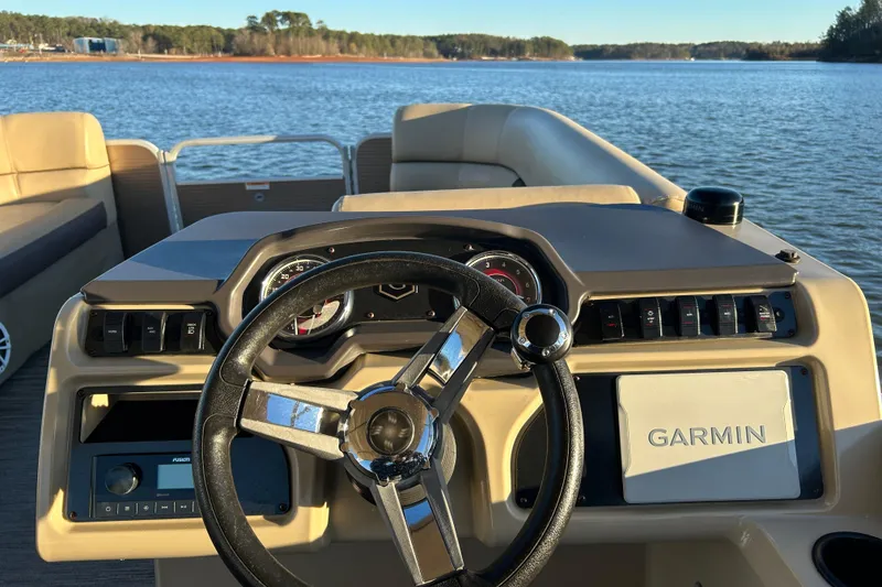 Slide: The Image of 2022 Godfrey Sweetwater 2286 C boat dashboard with Garmin navigation on a lake. - 20