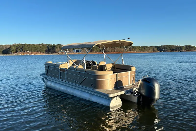 Slide: The Image of 2022 Godfrey Sweetwater 2286 C pontoon boat on a serene lake. - 6