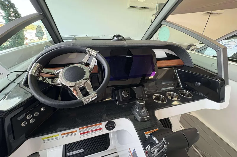 Slide: The Image of 2026 Monterey Elite 30 OB boat dashboard with steering wheel and modern controls. - 16