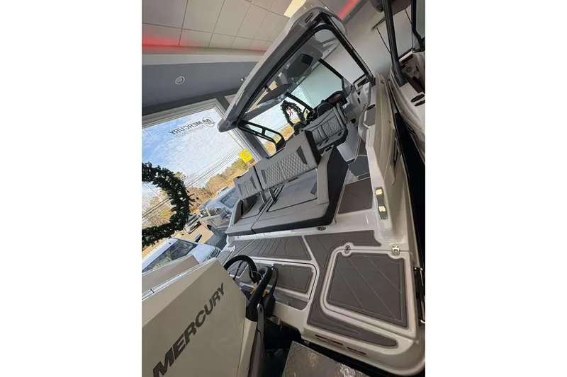 Slide: The Image of 2026 Monterey Elite 30 OB boat interior with Mercury engine, displayed in showroom. - 4