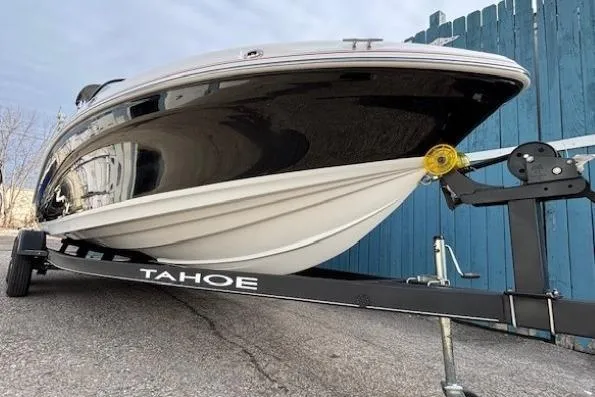Slide: The Image of 2019 Tahoe 500 TS boat on trailer, parked near blue fence. - 2