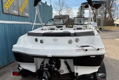 Slide: The Image of 2019 Tahoe 500 TS boat, white exterior, parked outdoors near a blue wooden fence. - 4
