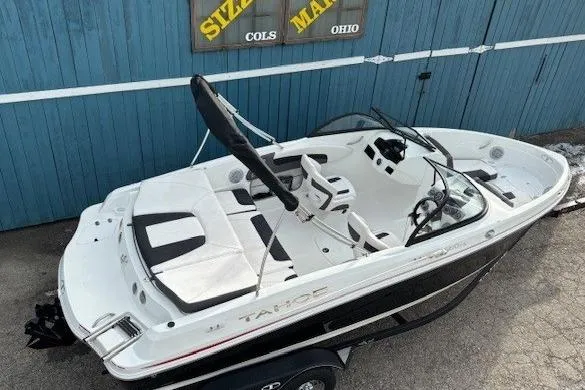 Slide: The Image of 2019 Tahoe 500 TS boat with sleek design, parked near a blue building. - 5