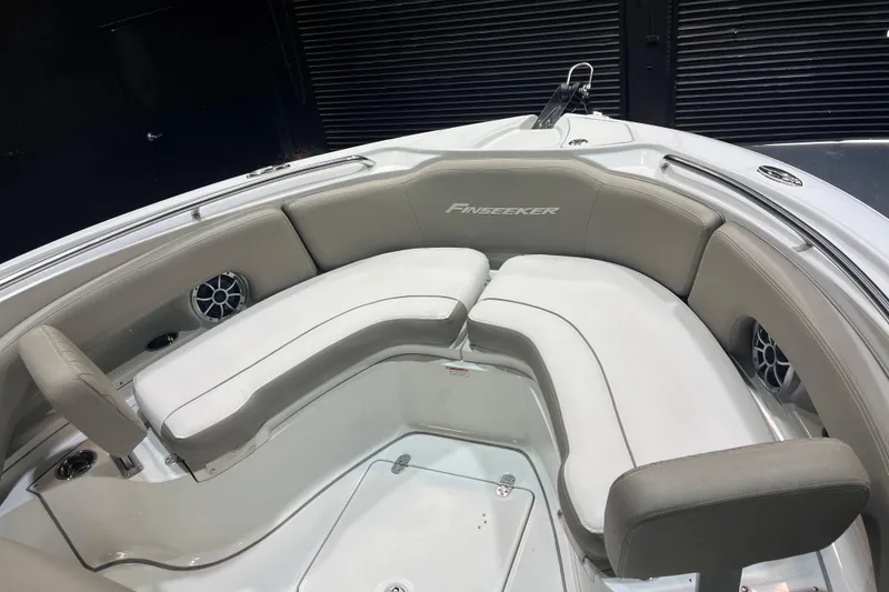 Slide: The Image of 2023 Crownline 220 CC Finseeker boat interior with cushioned seating and speakers. - 11