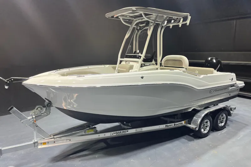 Slide: The Image of 2023 Crownline 220 CC Finseeker boat on trailer, sleek design, indoor display. - 2