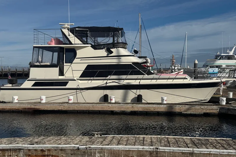 The Image of 1988 Carmague 48 CPMY yacht docked at marina under clear blue sky. - 1