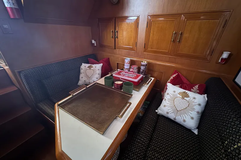 Slide: The Image of Cozy dining area in 1988 Carmague 48 CPMY yacht with decorative pillows and wooden cabinetry. - 12