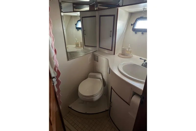 Slide: The Image of 1988 Carmague 48 CPMY yacht bathroom with toilet, sink, and mirror. - 15