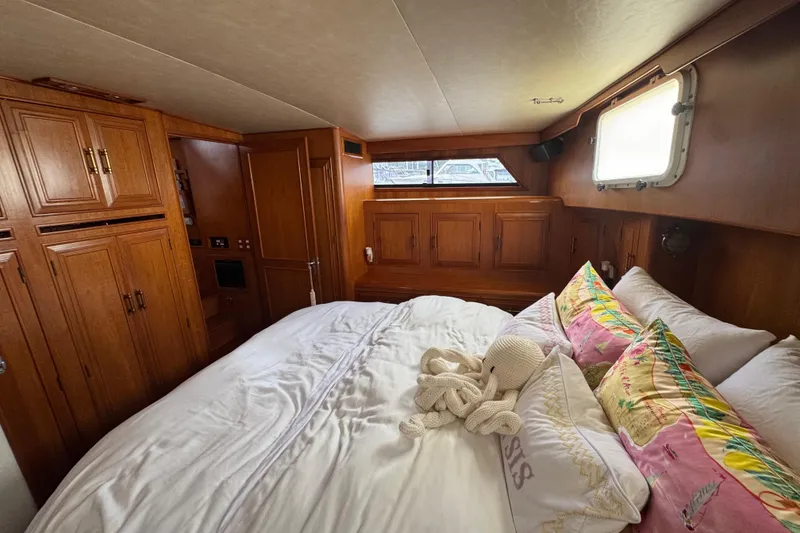Slide: The Image of Luxurious 1988 Carmague 48 CPMY yacht bedroom with wooden cabinetry and cozy bedding. - 19