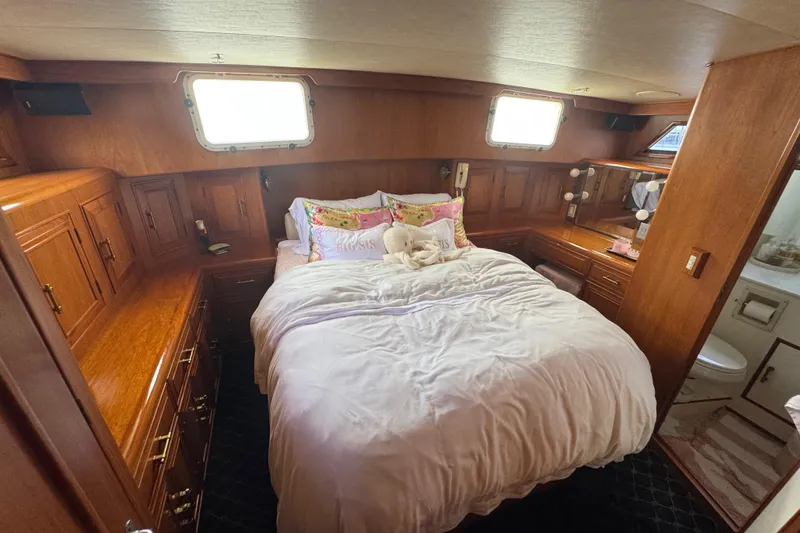 Slide: The Image of Luxurious 1988 Carmague 48 CPMY yacht bedroom with wood paneling and cozy bedding. - 22