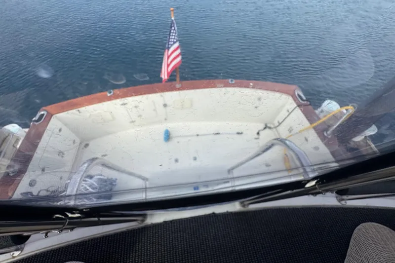 Slide: The Image of 1988 Carmague 48 CPMY yacht deck with American flag, overlooking calm water. - 23