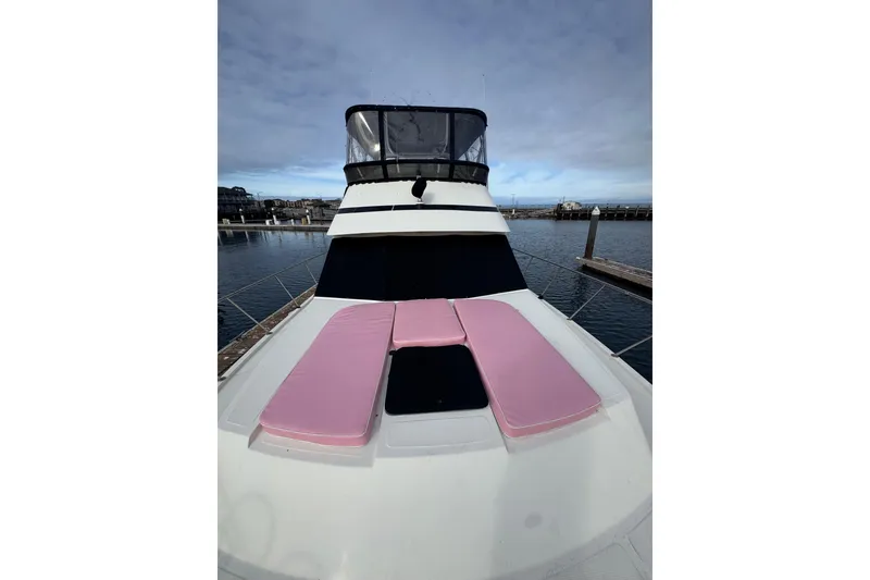 Slide: The Image of 1988 Carmague 48 CPMY yacht with pink deck cushions, docked at marina. - 25
