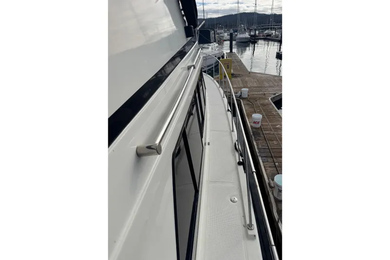 Slide: The Image of 1988 Carmague 48 CPMY yacht docked at marina, side view with railing and deck. - 27