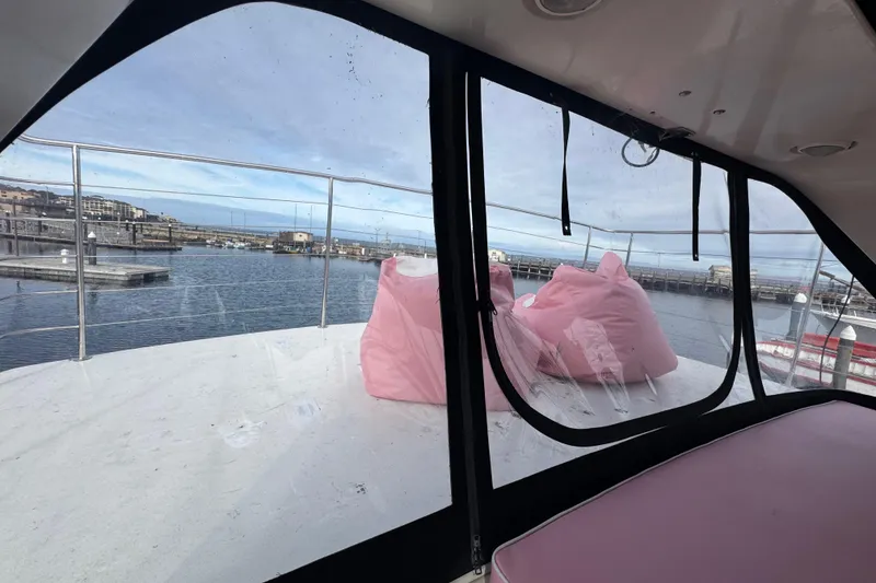 Slide: The Image of 1988 Carmague 48 CPMY yacht with pink bean bags on deck, overlooking marina. - 29