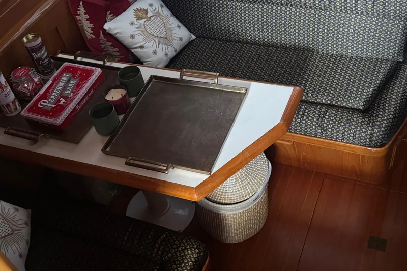 Slide: The Image of Cozy 1988 Carmague 48 CPMY yacht interior with cushioned seating and decorative pillows. - 3