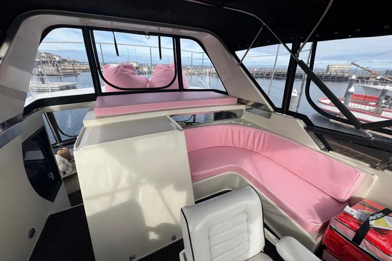 Slide: The Image of Interior of 1988 Carmague 48 CPMY yacht with pink seating and waterfront view. - 33