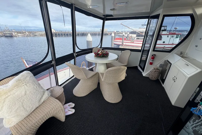 Slide: The Image of Luxurious 1988 Carmague 48 CPMY yacht interior with wicker chairs and marina view. - 35