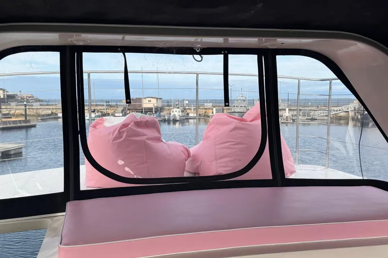 Slide: The Image of 1988 Carmague 48 CPMY yacht interior with pink cushions overlooking marina. - 36