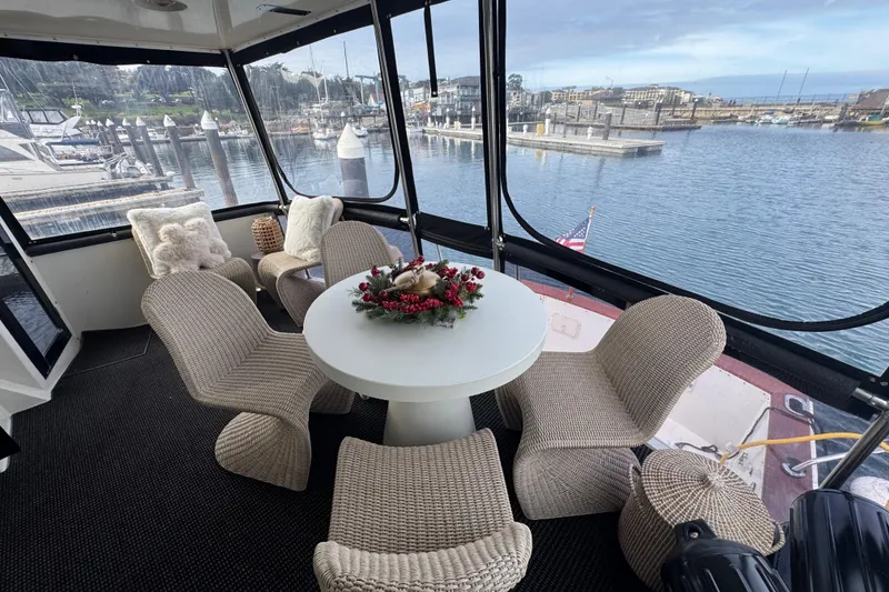 Slide: The Image of 1988 Carmague 48 CPMY yacht interior with wicker chairs, table, and marina view. - 38