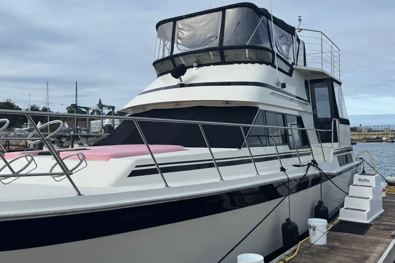 Slide: The Image of 1988 Carmague 48 CPMY yacht docked at marina, featuring sleek design and spacious deck. - 41