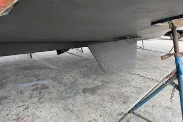 Slide: The Image of 1988 Camargue 48 CPMY boat hull on dry dock with visible support stands. - 49