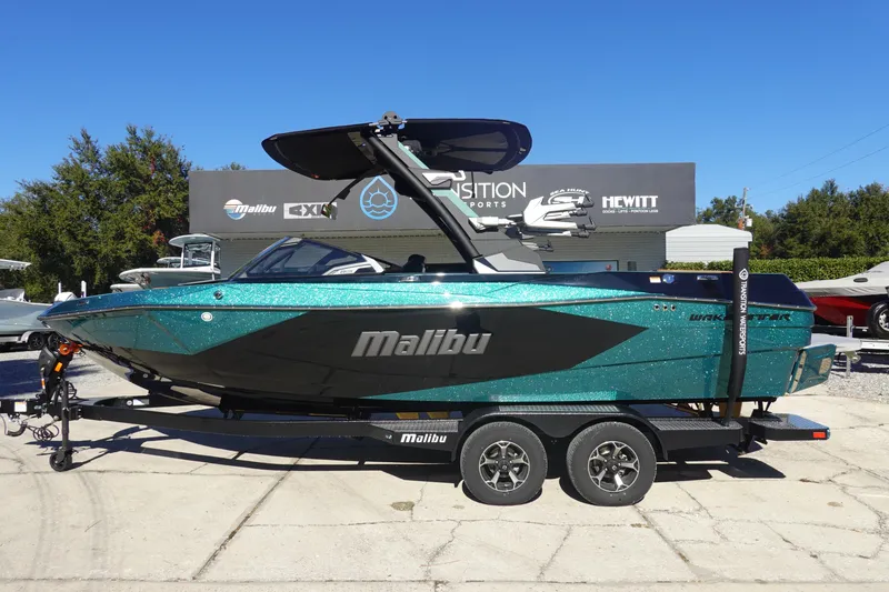 The Image of 2026 Malibu Wakesetter 23 LSV boat in teal and black on trailer, outdoor display. - 0