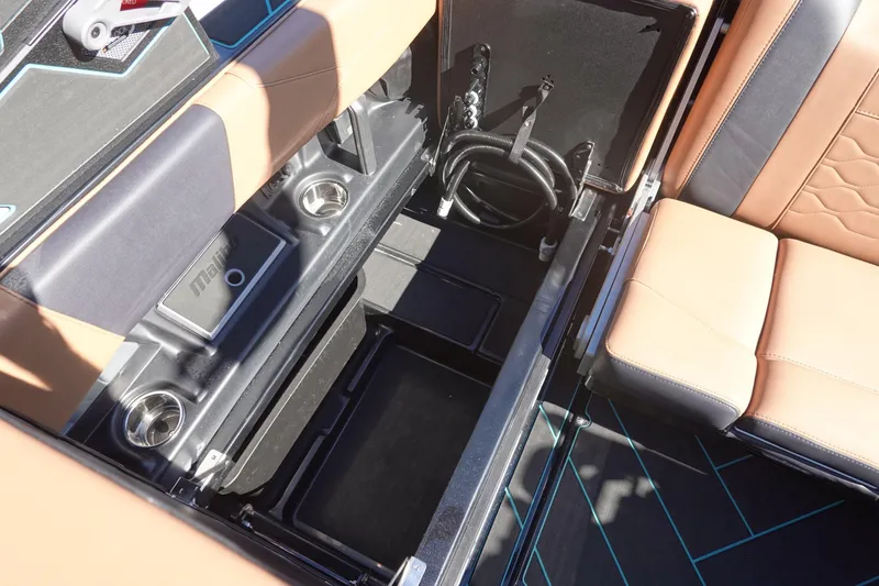 Slide: The Image of 2026 Malibu Wakesetter 23 LSV interior storage compartment with tan and black seating. - 15