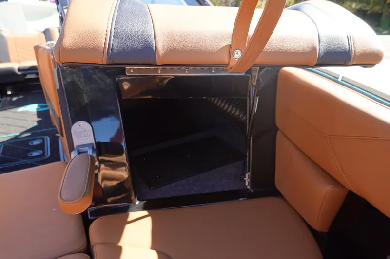 Slide: The Image of 2026 Malibu Wakesetter 23 LSV interior storage compartment with tan and black upholstery. - 36
