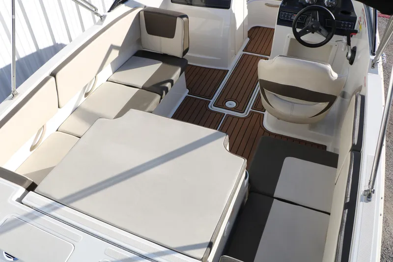 Slide: The Image of 2009 Bayliner VR4 Bowrider I/O interior with beige seating and wood-style flooring. - 14