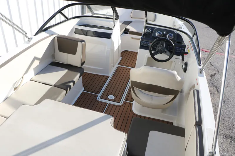 Slide: The Image of 2009 Bayliner VR4 Bowrider I/O interior with seating and steering wheel, featuring wood-style flooring. - 15