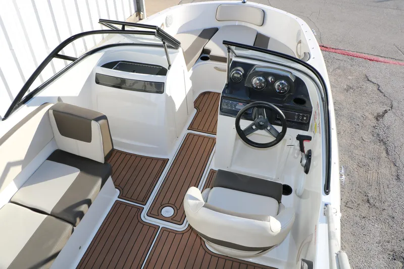 Slide: The Image of 2009 Bayliner VR4 Bowrider I/O interior with seating and steering wheel, featuring wood-style flooring. - 17