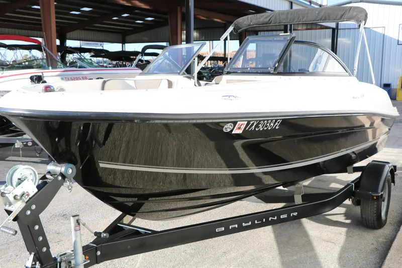 Slide: The Image of 2009 Bayliner VR4 Bowrider I/O boat on trailer in a marina setting. - 6