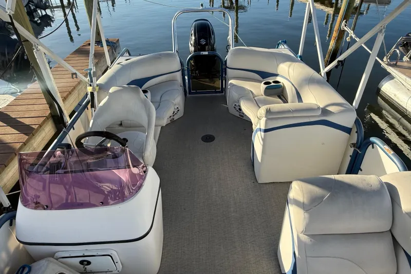Slide: The Image of 2021 Aloha Pontoon Tropical Series 23 with spacious seating and helm, docked by the water. - 16