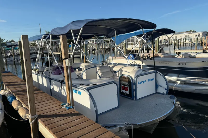 Slide: The Image of 2021 Aloha Pontoon Tropical Series 23 docked, featuring spacious seating and canopy. - 2
