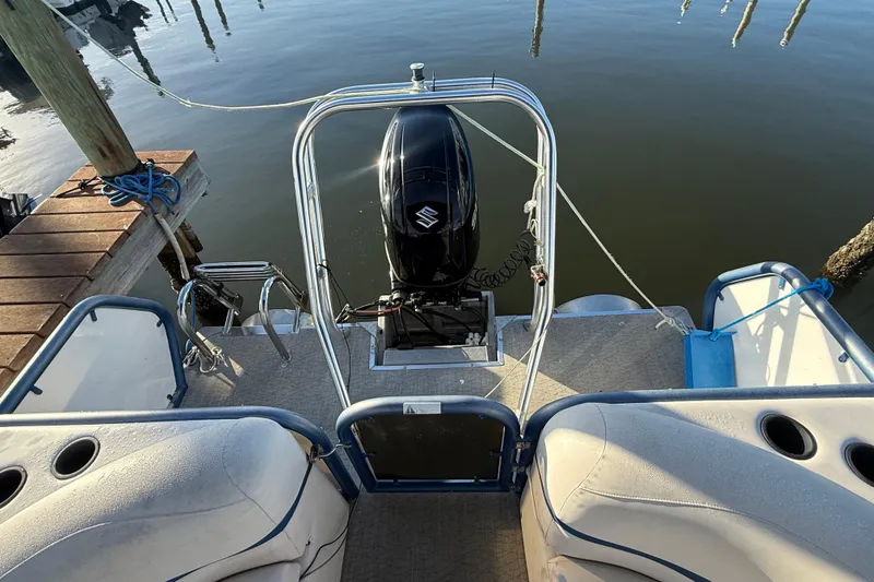 Slide: The Image of 2021 Aloha Pontoon Tropical Series 23 with outboard motor, docked on calm water. - 5