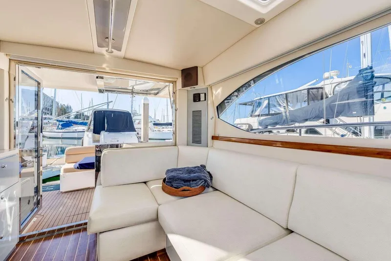 Slide: The Image of Interior of a 2007 Riviera yacht with white seating and marina view. - 13