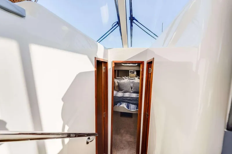 Slide: The Image of Interior view of a 2007 Riviera yacht cabin with cozy bedding and wooden accents. - 15